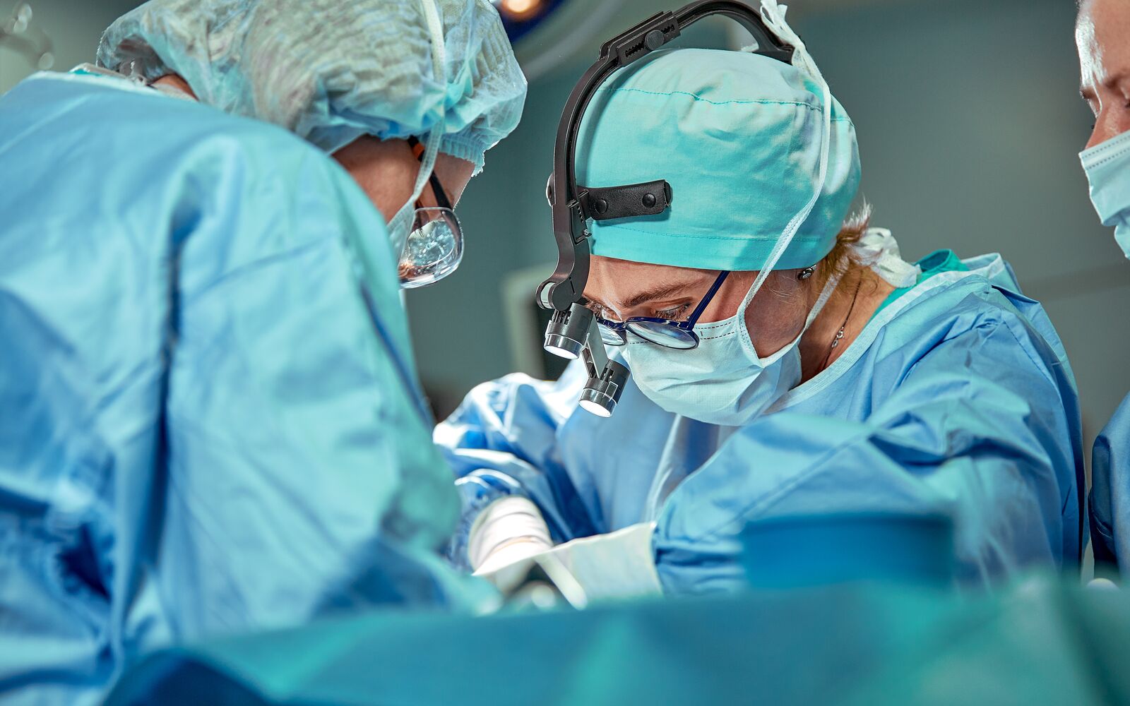 Group of surgeons looking at patient on operation table during their work; Shutterstock ID 1527639332; purchase_order: Main Visual; job: ; client: ; other: